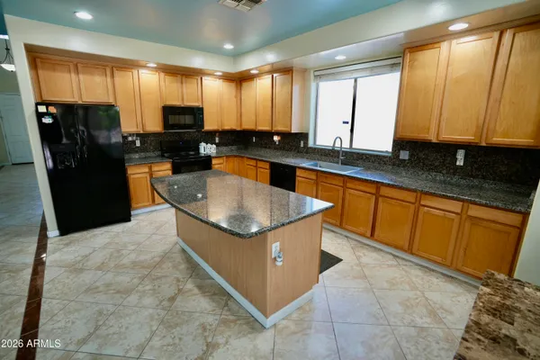 a kitchen with stainless steel appliances granite countertop a sink counter space cabinets and a large window
