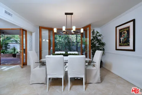 a living room with furniture a dining table and a chandelier