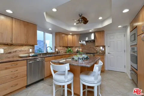 a kitchen with stainless steel appliances granite countertop wooden cabinets stove top oven and sink