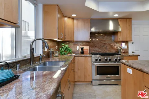 a kitchen with stainless steel appliances granite countertop a stove and a sink