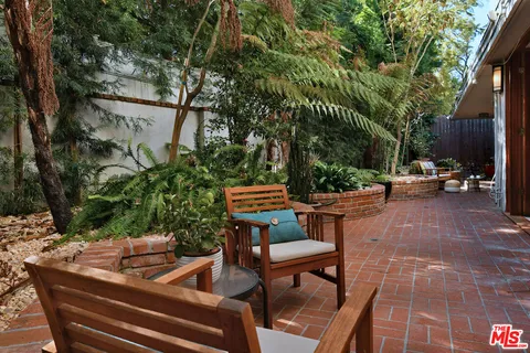 a living room with furniture a potted plant and a large window