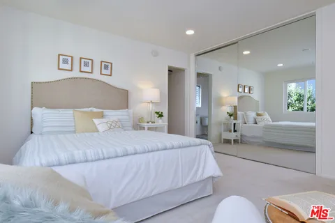 a bedroom with bed and glass window