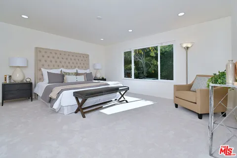 a bedroom with bed and large windows