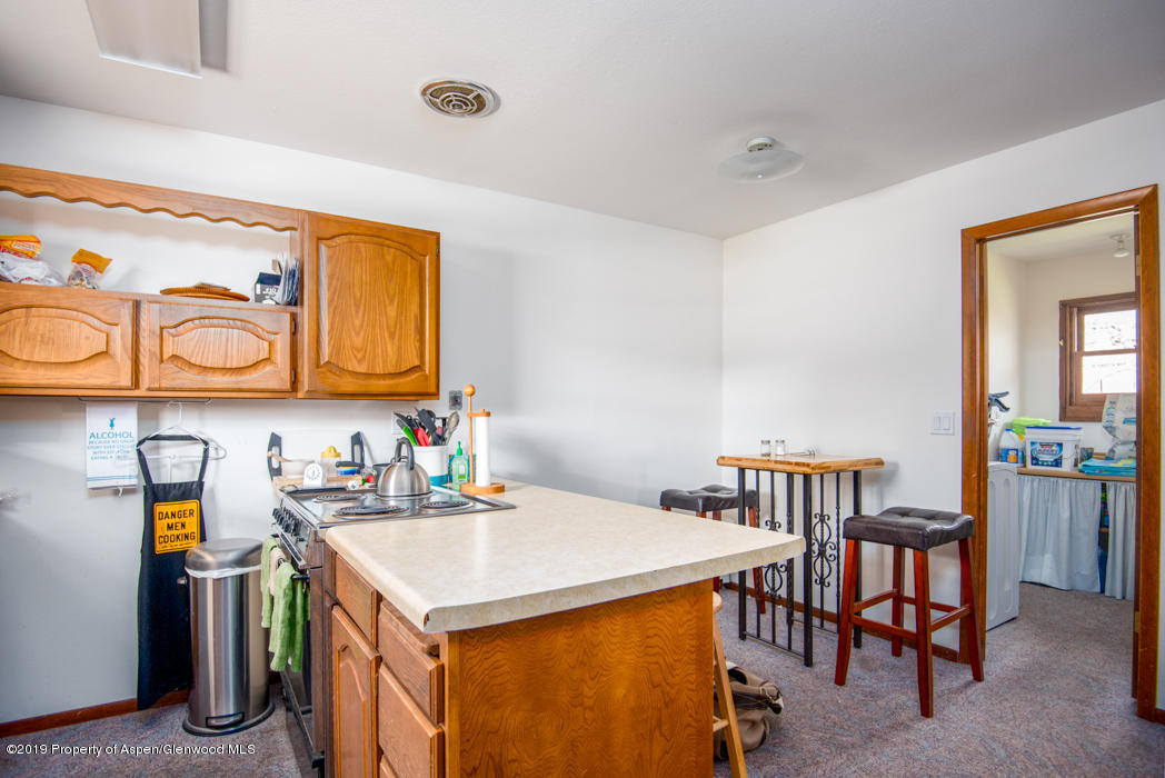 820 East 5th Street Rifle, CO 81650 - Photo 8 of 20 a utility room with stainless steel appliances a stove a table and chairs in it