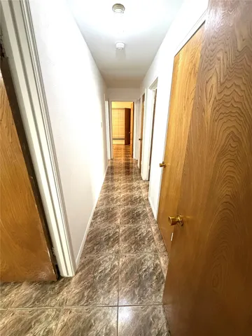 a view of a big room with wooden floor and windows