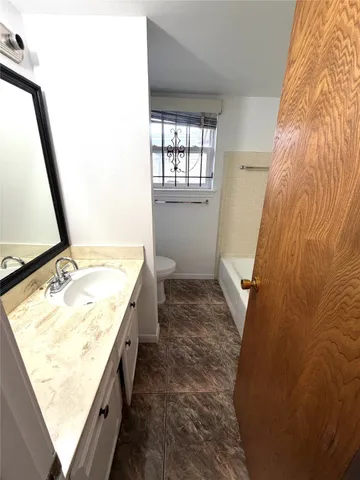 a spacious bathroom with a tub sink and mirror