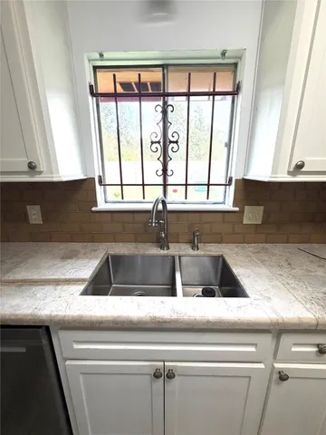 a kitchen with granite countertop white cabinets and white appliances