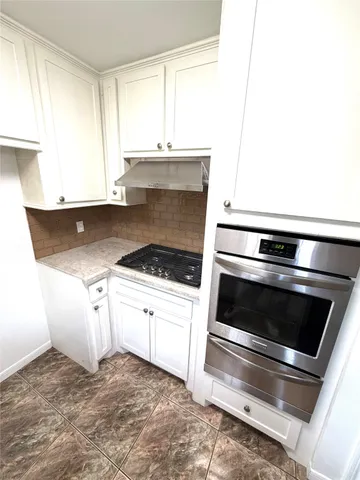 an empty room with windows and ceiling fan