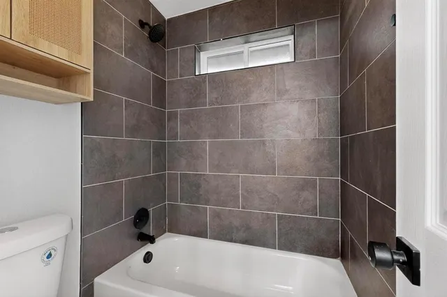 a bath tub sitting next to a white toilet and a sink