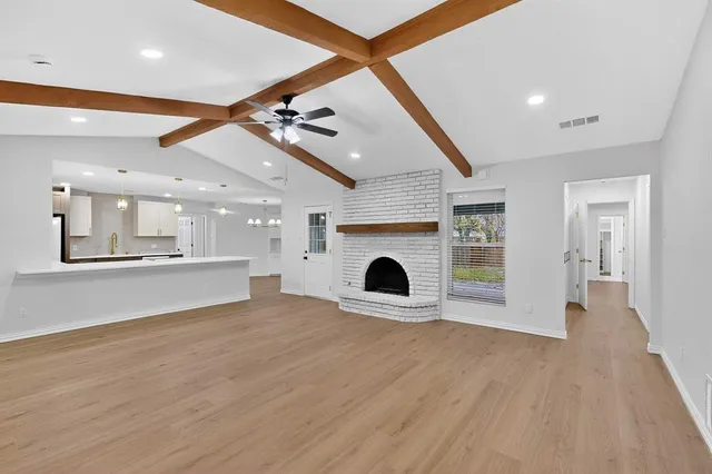 a view of an empty room with a fireplace and a fan