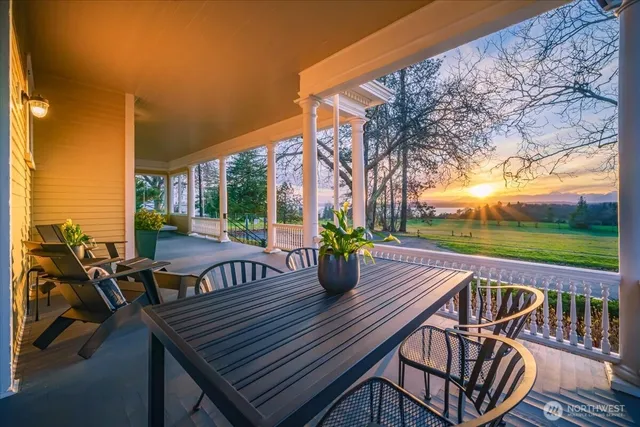 a view of a patio with table and chairs potted plants with wooden floor and fence
