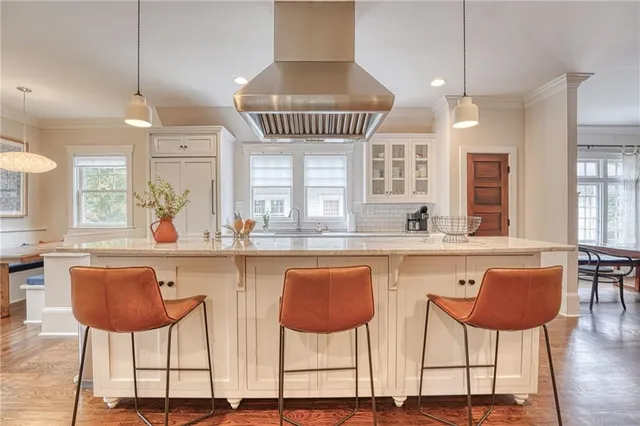 a kitchen with stainless steel appliances a counter space and a chair