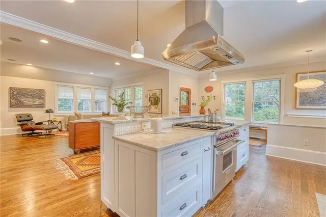 a kitchen with a stove and a view of living room