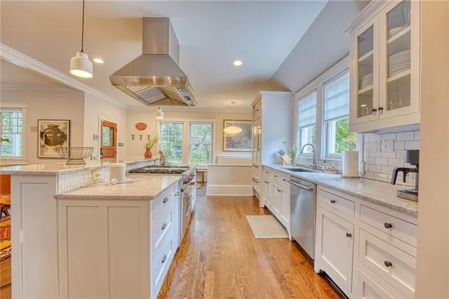 a large kitchen with a large counter top sink and stainless steel appliances