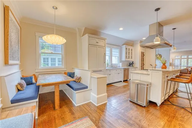 a living room with stainless steel appliances kitchen island granite countertop furniture and a wooden floor
