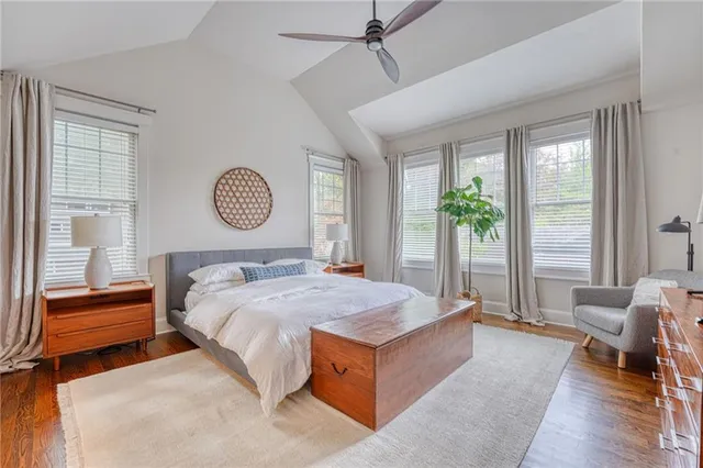 a bed sitting in a spacious bedroom next to a window