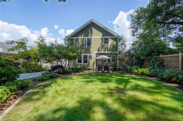 a view of a patio with plants and chairs under an umbrella