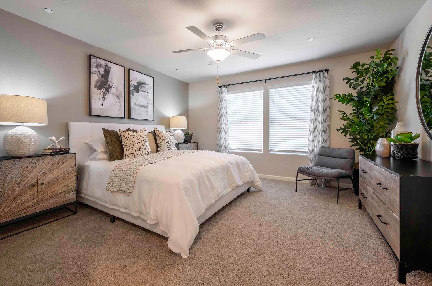 1553 Seneca Drive, Unit 86 Madera, CA 93637 - Photo 11 of 21 a spacious bedroom with a large bed and a chandelier
