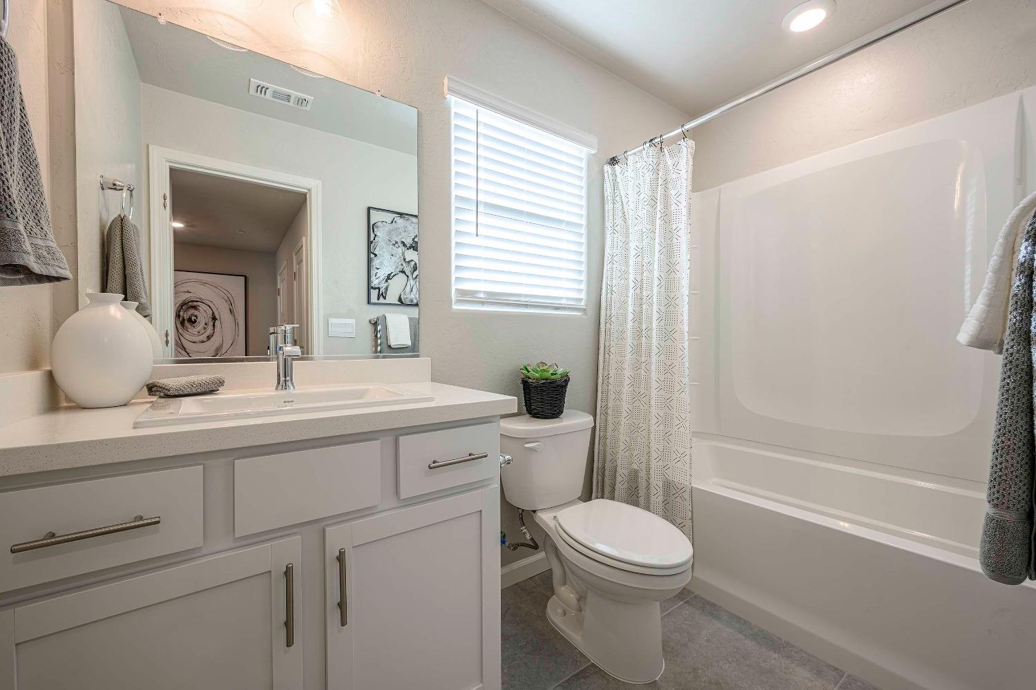 1553 Seneca Drive, Unit 86 Madera, CA 93637 - Photo 15 of 21 a bathroom with a toilet a sink and a bathtub