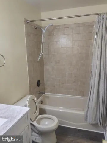 a bathroom with a granite countertop toilet and a shower