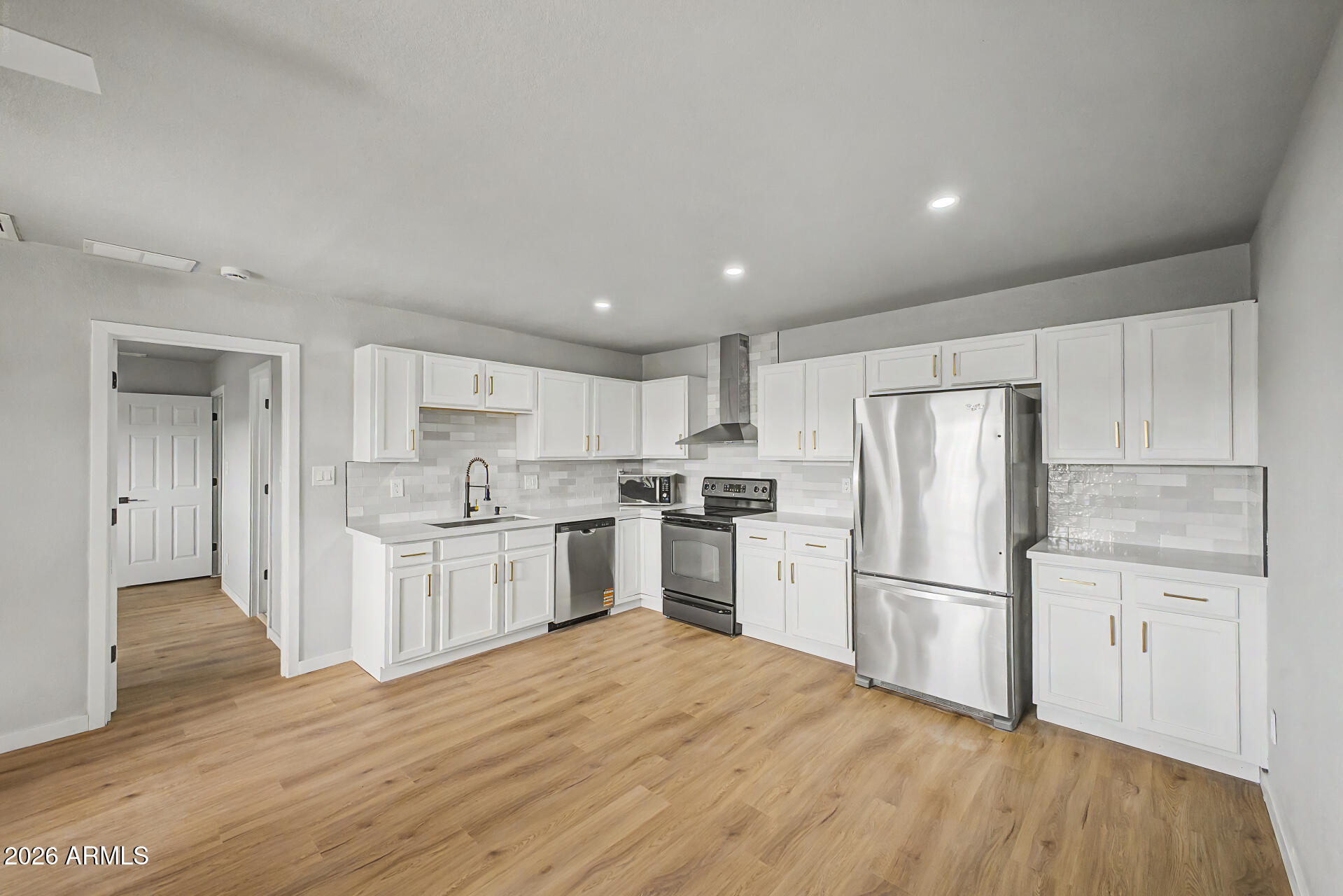 1440 North Idaho Road, Unit 1060 Apache Junction, AZ 85119 - Photo 11 of 16 a kitchen with a refrigerator a stove top oven and white walls