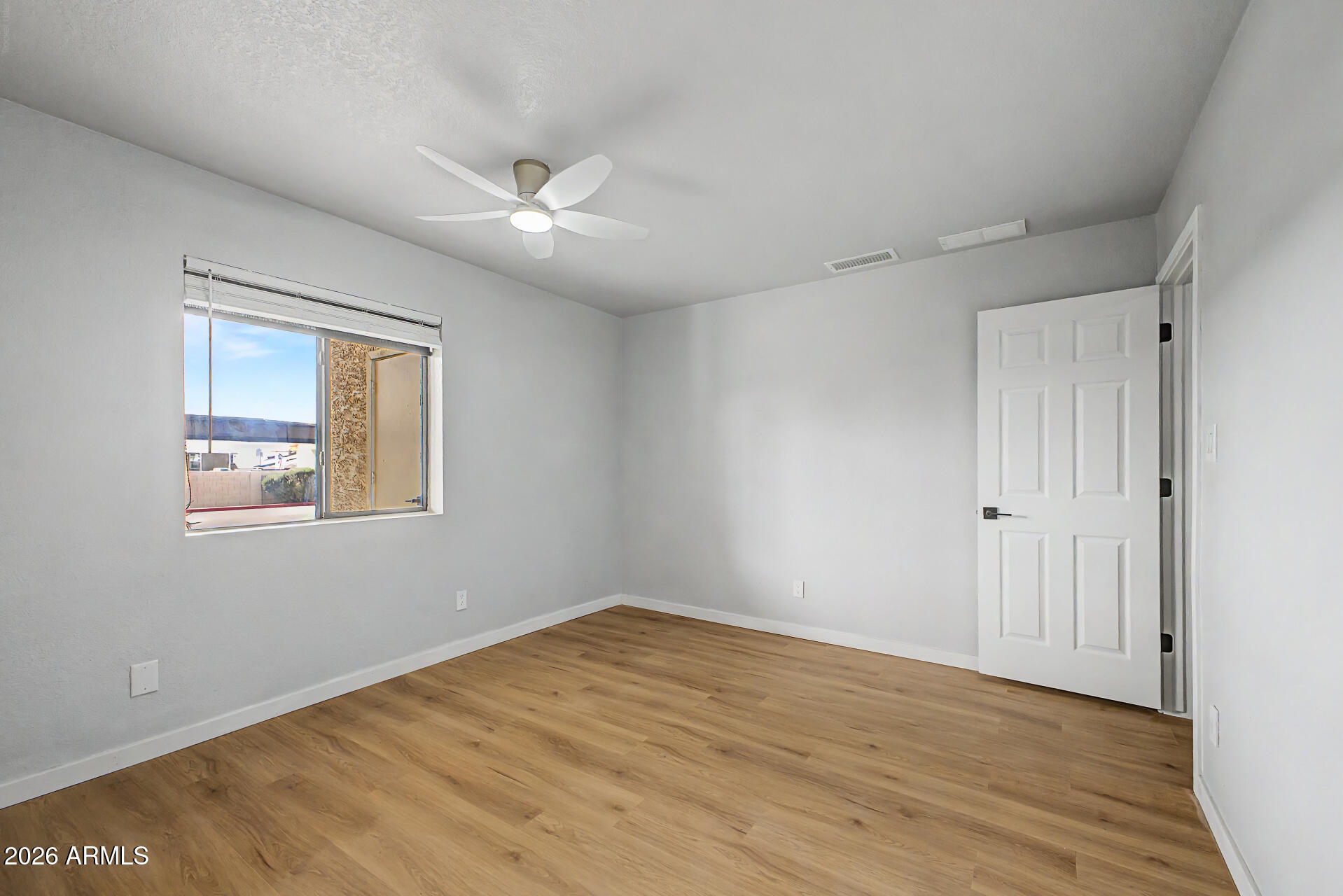 1440 North Idaho Road, Unit 1060 Apache Junction, AZ 85119 - Photo 13 of 16 a view of an empty room with wooden floor and a window