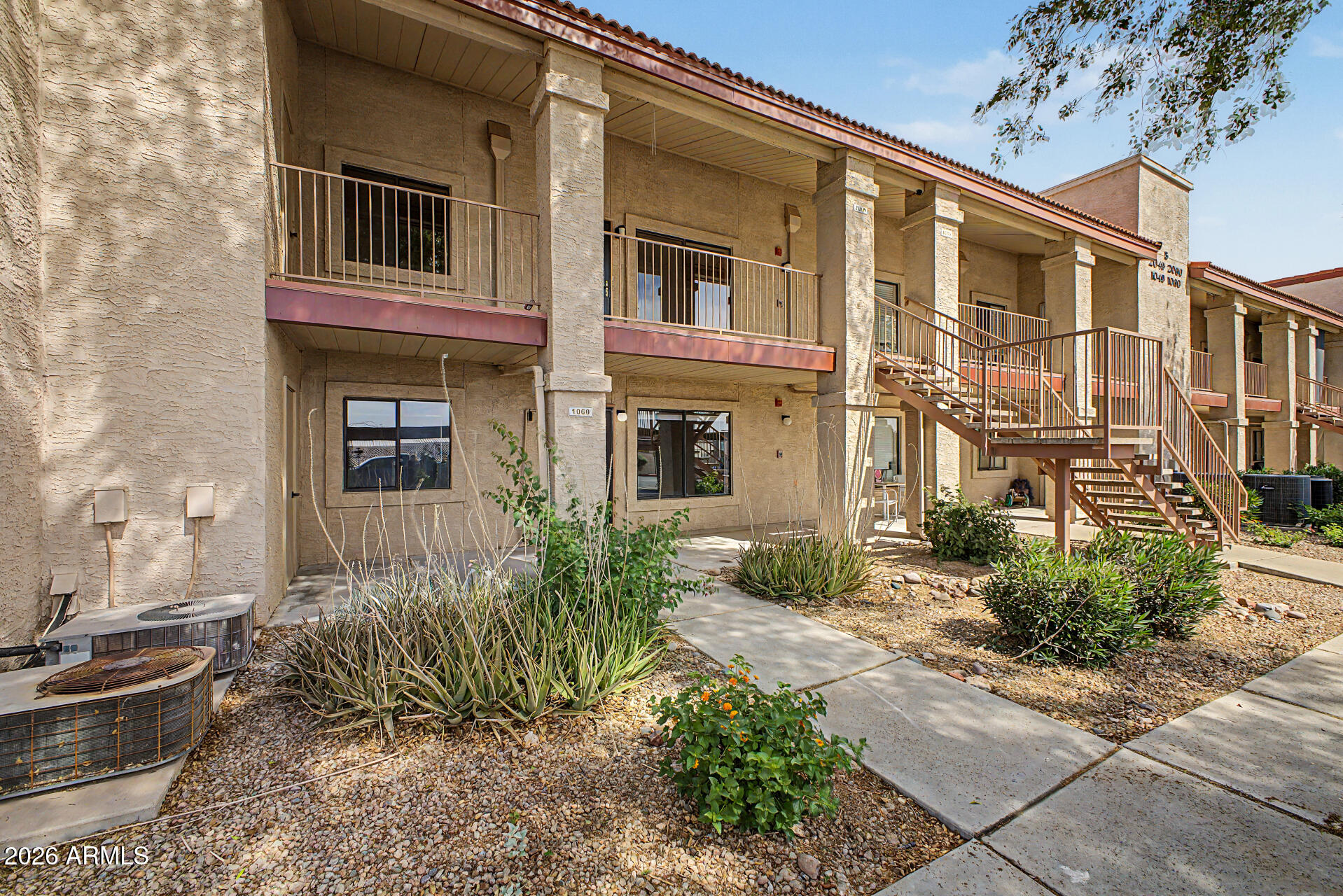 1440 North Idaho Road, Unit 1060 Apache Junction, AZ 85119 - Photo 2 of 16 a front view of a house with a yard