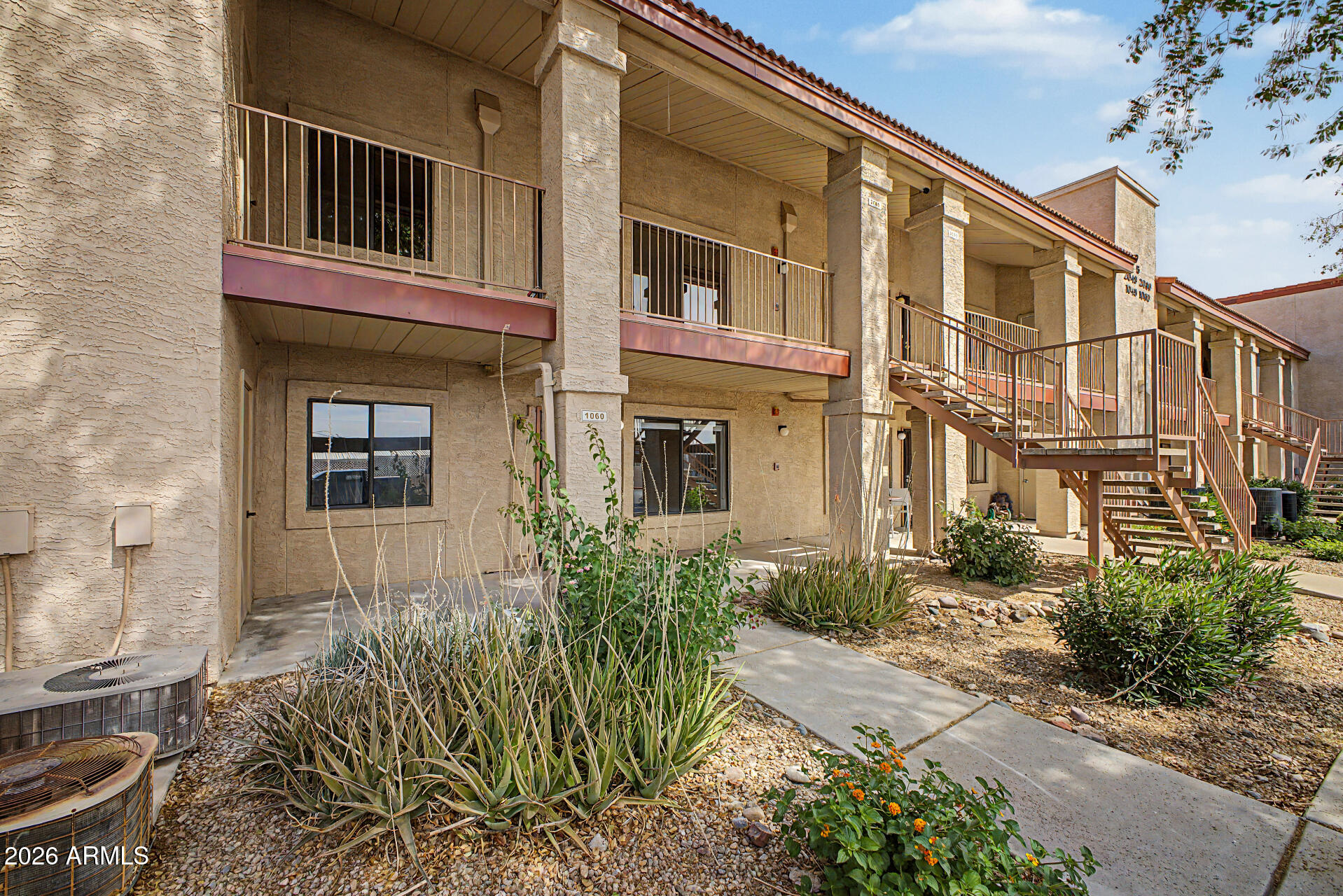 1440 North Idaho Road, Unit 1060 Apache Junction, AZ 85119 - Photo 3 of 16 a front view of a house with a yard