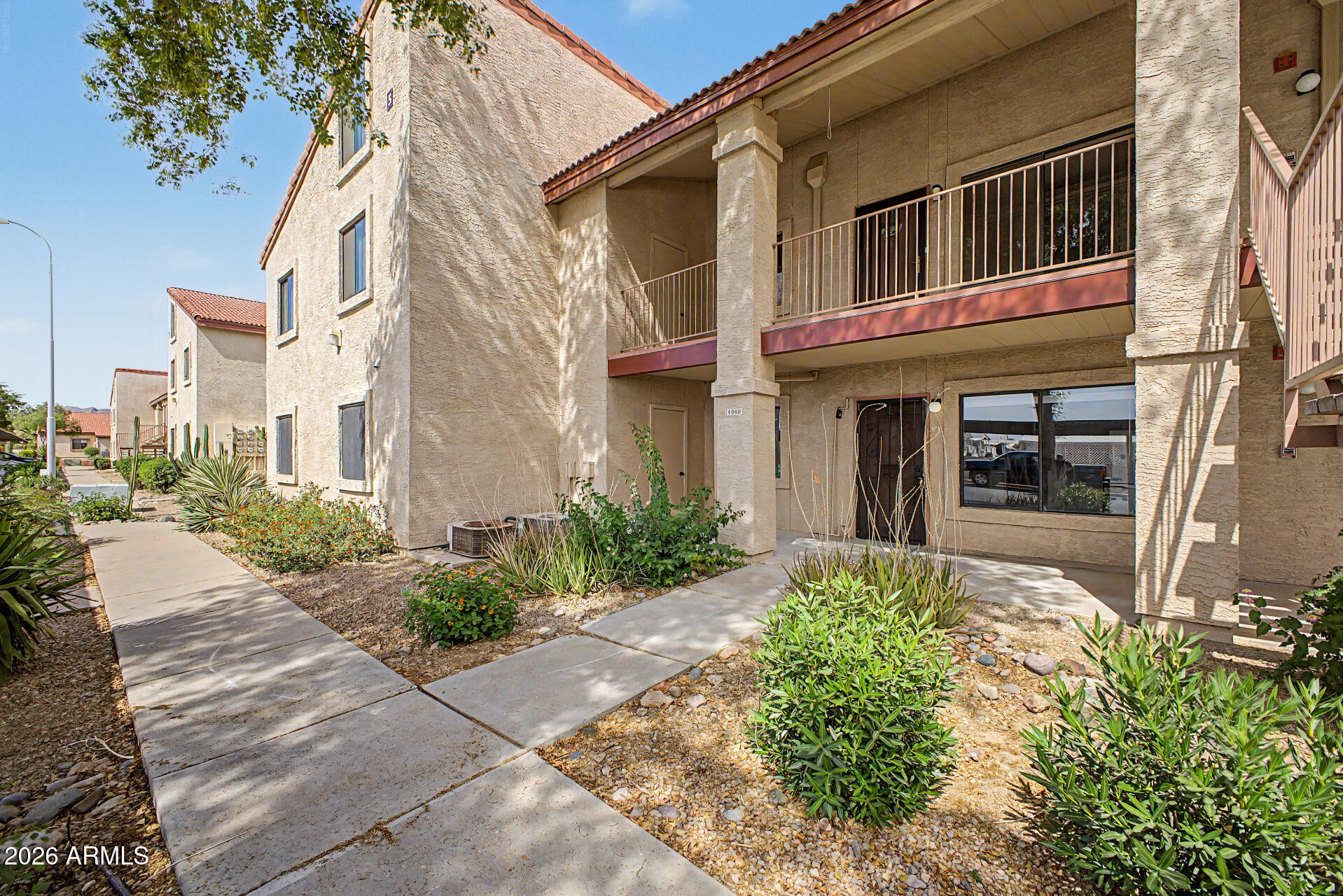 1440 North Idaho Road, Unit 1060 Apache Junction, AZ 85119 - Photo 4 of 16 a front view of a brick house with a yard