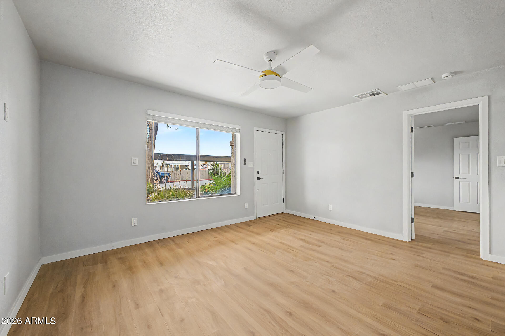 1440 North Idaho Road, Unit 1060 Apache Junction, AZ 85119 - Photo 8 of 16 a view of an empty room with a window and wooden floor