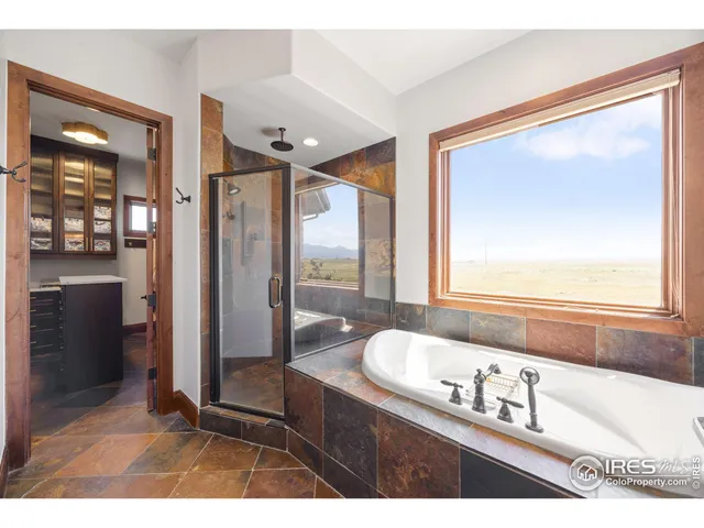 a bathroom with a tub a sink and mirror