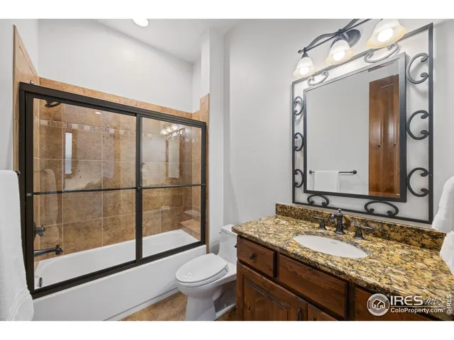 a bathroom with a granite countertop sink mirror vanity and toilet