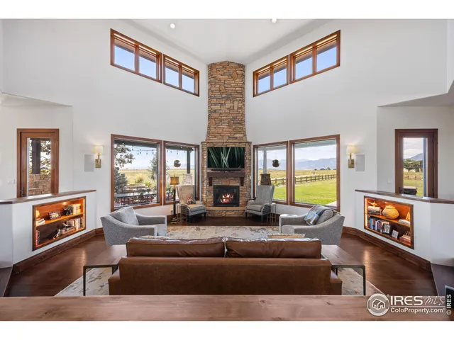 a living room with fireplace furniture and a large window