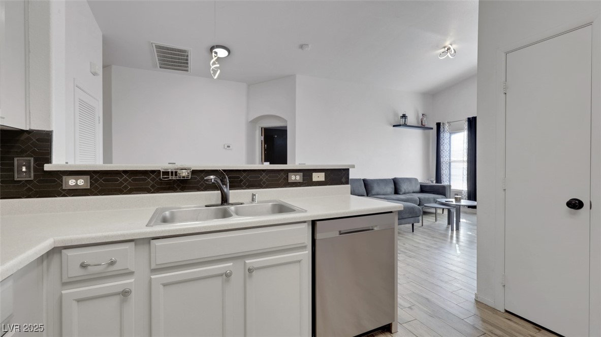 5940 High Steed Street, Unit 101 Henderson, NV 89011 - Photo 12 of 30 Kitchen featuring light cabinets, light countertops, dishwasher, and tasteful backsplash