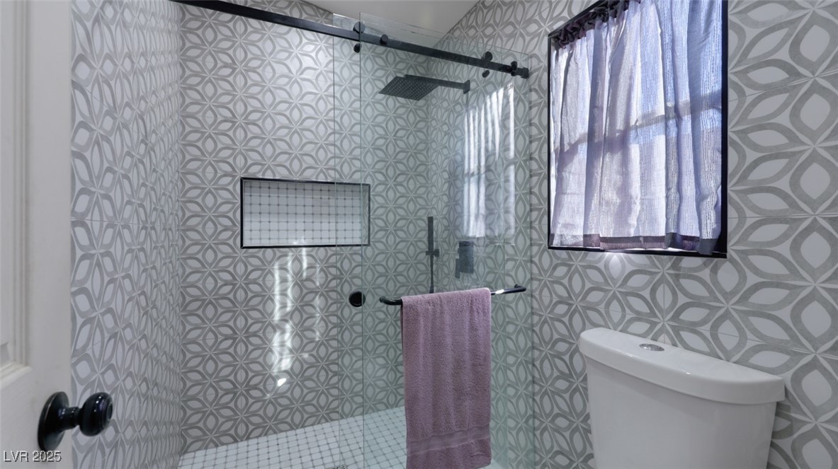 5940 High Steed Street, Unit 101 Henderson, NV 89011 - Photo 19 of 30 Bathroom with tiled shower, plenty of natural light, and tile walls