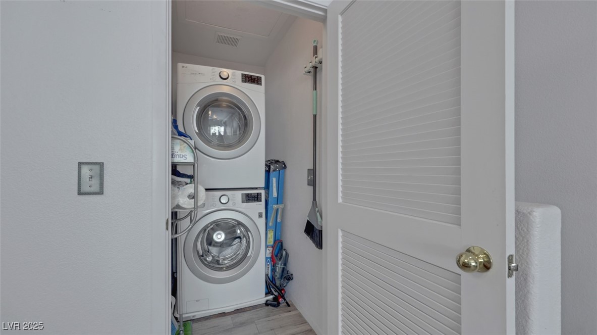 5940 High Steed Street, Unit 101 Henderson, NV 89011 - Photo 22 of 30 Washroom featuring stacked washer / drying machine and light wood-look floors