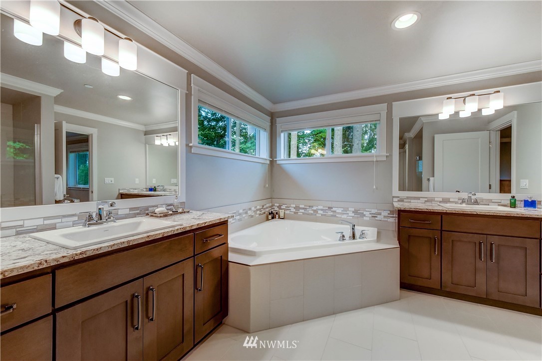 1607 233rd Street Southeast Bothell, WA 98021 - Photo 20 of 36 a bathroom with a tub a sink double vanity and a mirror