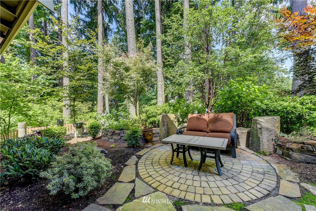 1607 233rd Street Southeast Bothell, WA 98021 - Photo 34 of 36 a wooden bench sitting in backside of a house with potted plants