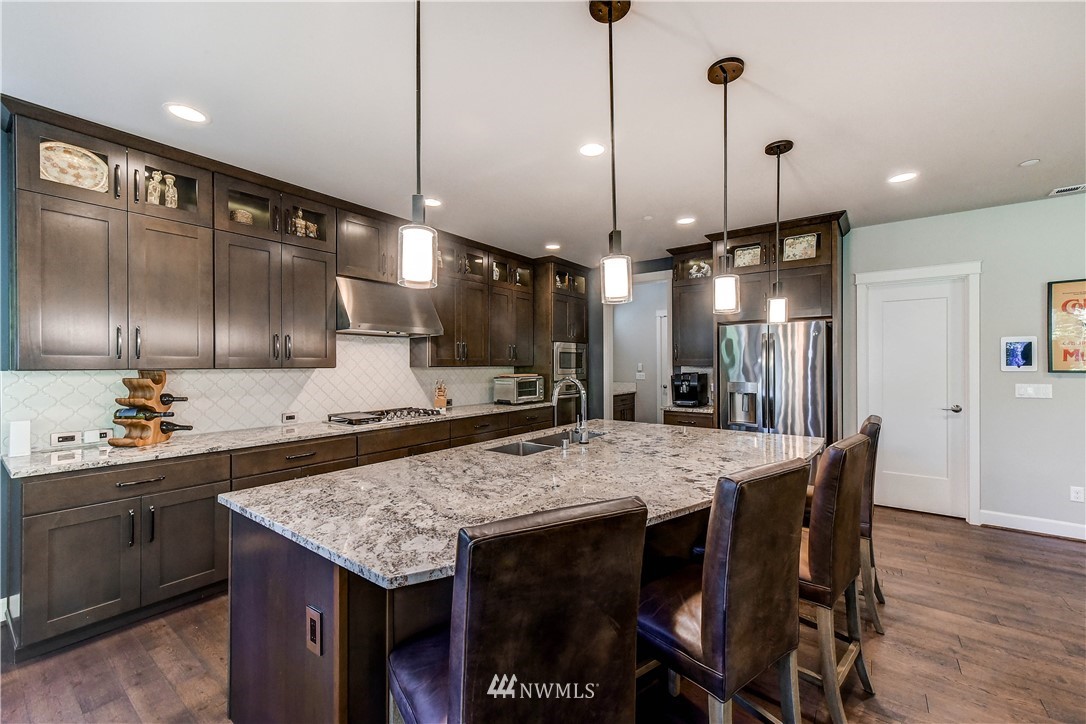 1607 233rd Street Southeast Bothell, WA 98021 - Photo 10 of 36 a kitchen with stainless steel appliances granite countertop wooden floors and sink