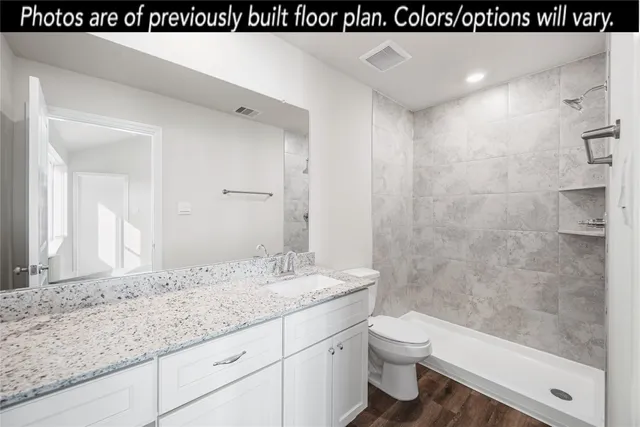 a bathroom with a granite countertop sink a toilet and shower