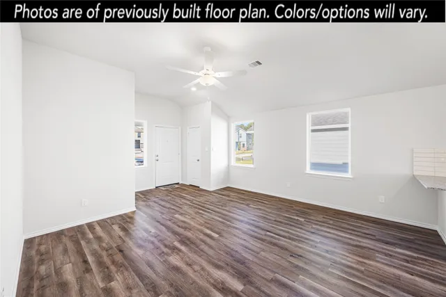 a view of empty room with window and wooden floor