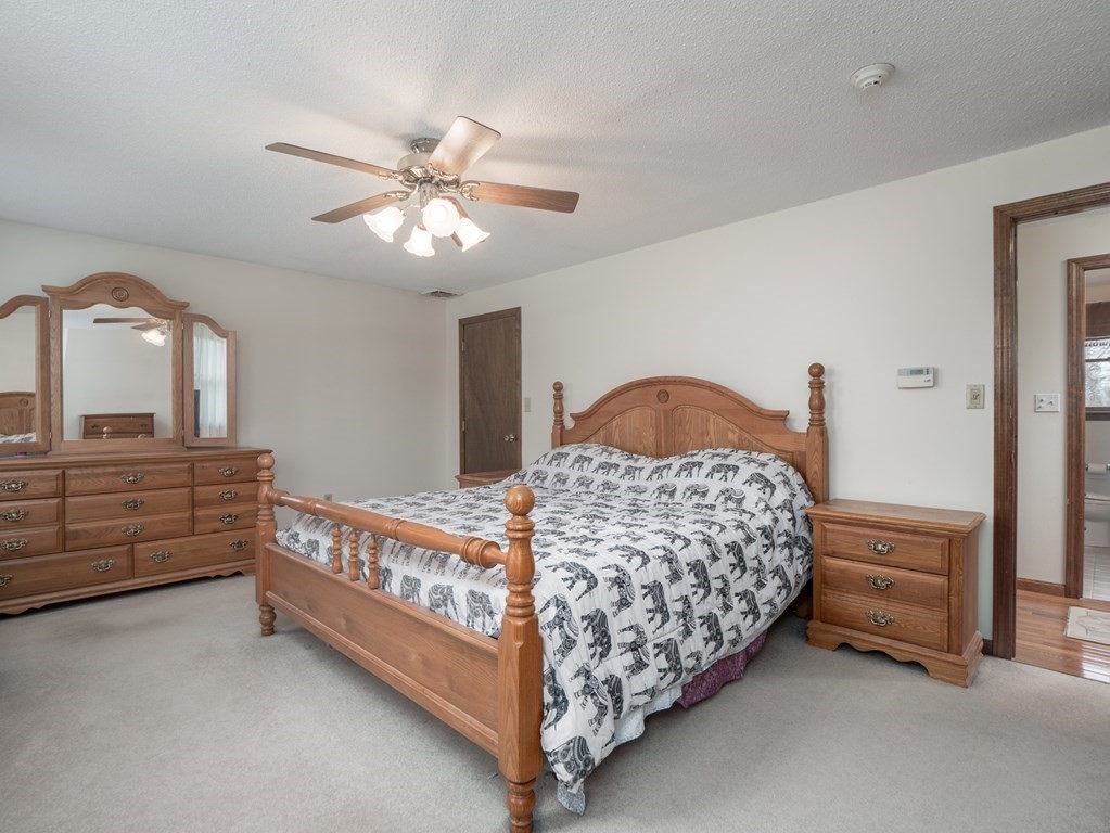 21 Partridge Road Dracut, MA 01826 - Photo 29 of 42 a bedroom with a bed and a chandelier