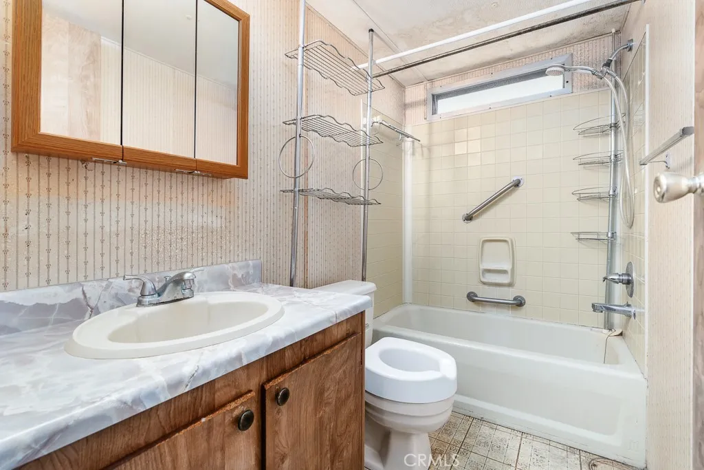 1700 South State Street, Unit 76 Hemet, CA 92543 - Photo 28 of 36 a bathroom with a granite countertop sink a toilet and shower
