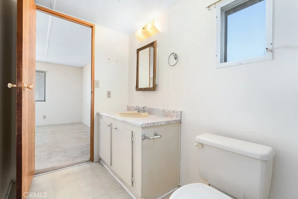 1700 South State Street, Unit 76 Hemet, CA 92543 - Photo 29 of 36 a bathroom with a sink a toilet and mirror