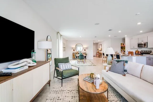 a living room with furniture and a view of kitchen
