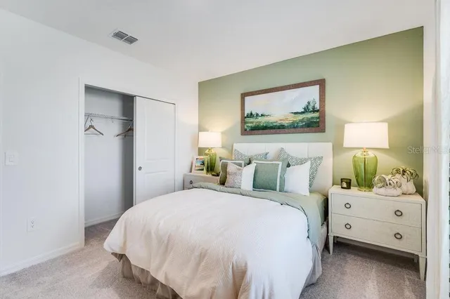 a bedroom with a bed and a painting on the wall