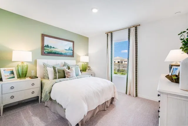 a bedroom with a bed a couch and dresser with wooden floor