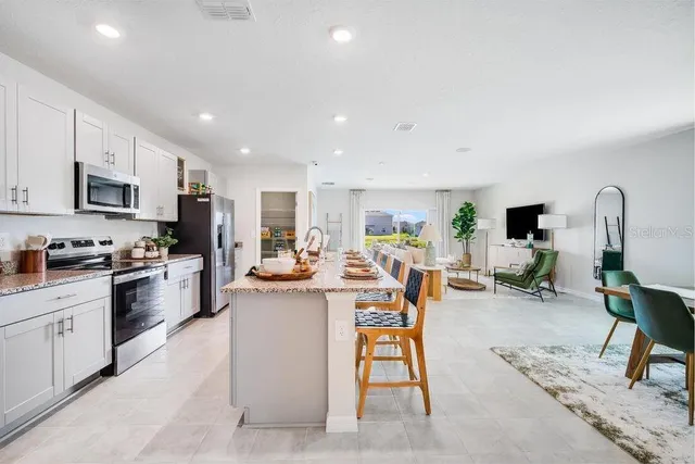 a view of kitchen with stainless steel appliances granite countertop lots of counter top space