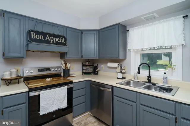 a kitchen with a sink cabinets and stainless steel appliances