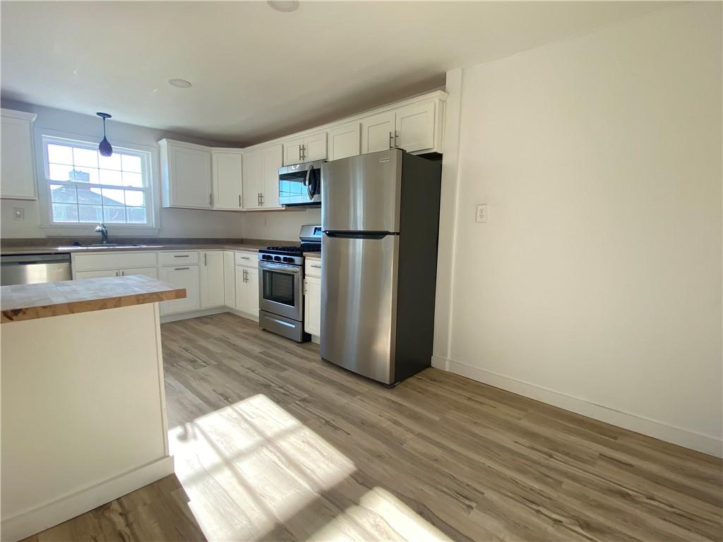 380 Vanadium Road Pittsburgh, PA 15243 - Photo 10 of 23 a kitchen with a refrigerator a sink dishwasher with a dining table and chairs